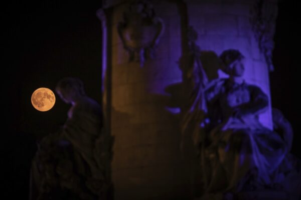 A superlua aparece atrás da estátua na Place de la République, em Paris, na França, nesta segunda (19). — Foto: AP